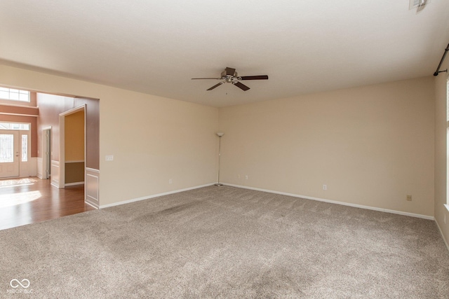 unfurnished room featuring a ceiling fan, carpet flooring, and baseboards