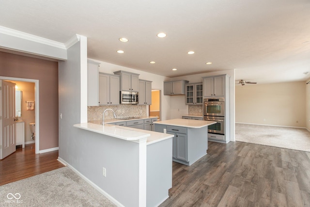 kitchen with stainless steel appliances, light countertops, and gray cabinetry