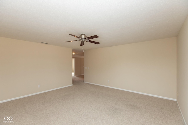 unfurnished room with a ceiling fan, light carpet, a textured ceiling, and baseboards