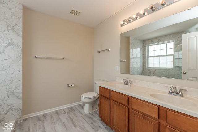 bathroom featuring visible vents, a sink, toilet, and wood finished floors