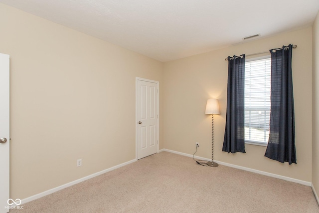 carpeted empty room featuring visible vents and baseboards