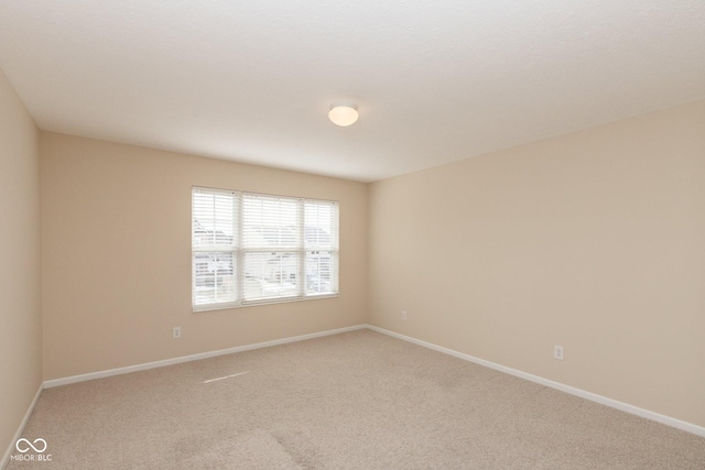 unfurnished room with carpet floors and baseboards