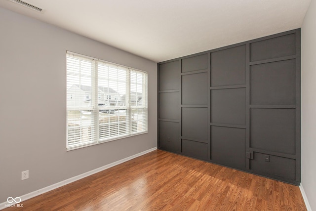 unfurnished bedroom featuring light wood-style flooring, visible vents, and baseboards