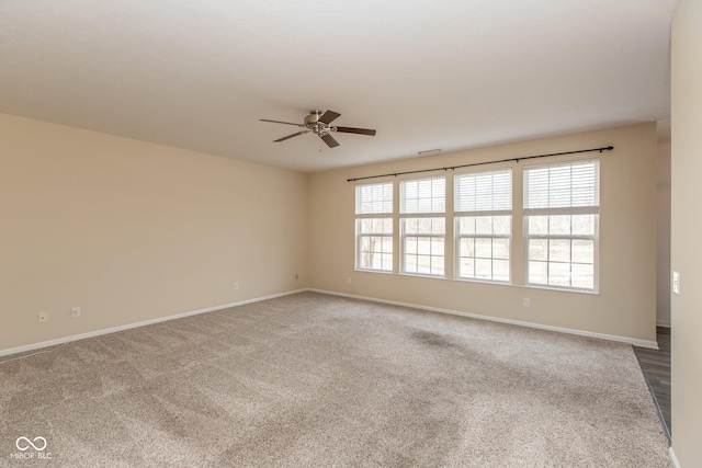 empty room featuring carpet flooring, a ceiling fan, and baseboards