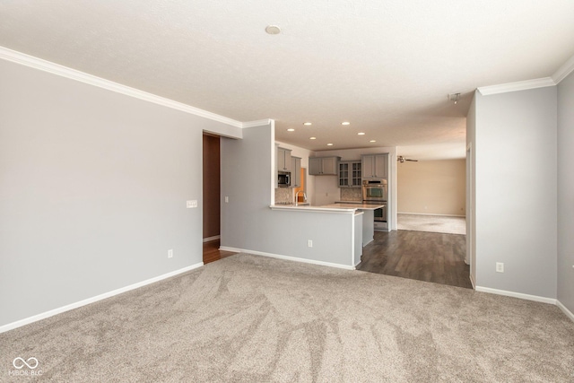 unfurnished living room featuring baseboards, dark carpet, crown molding, and recessed lighting