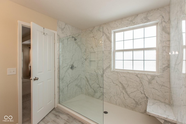 full bathroom featuring a marble finish shower and wood finished floors