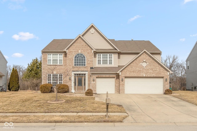 traditional home featuring a garage, driveway, brick siding, and central air condition unit