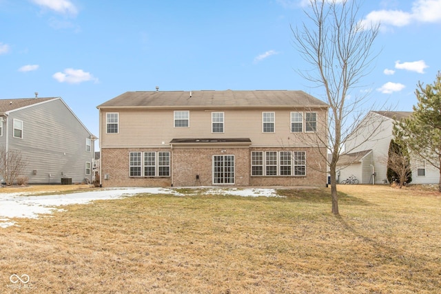 back of property with cooling unit, brick siding, and a lawn