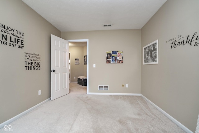 unfurnished bedroom featuring carpet flooring, visible vents, and baseboards