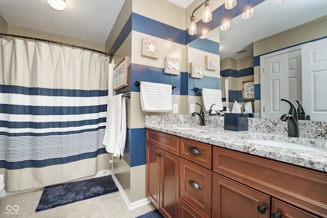 bathroom with double vanity, curtained shower, a sink, and tile patterned floors