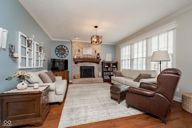 living area featuring a fireplace, crown molding, baseboards, and wood finished floors