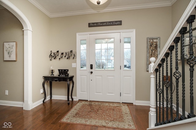 entrance foyer featuring baseboards, crown molding, arched walkways, and dark wood-type flooring