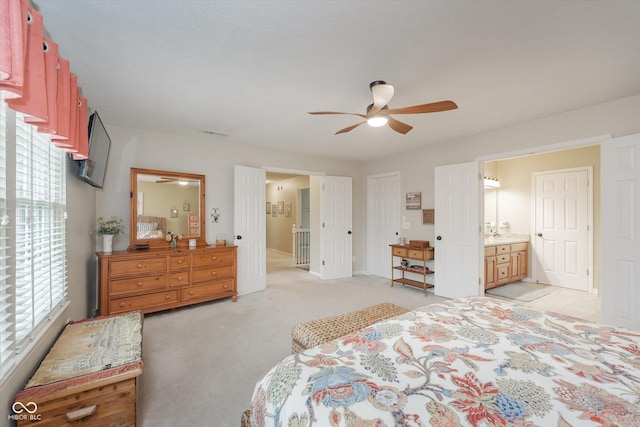 bedroom featuring ensuite bathroom, ceiling fan, and light colored carpet