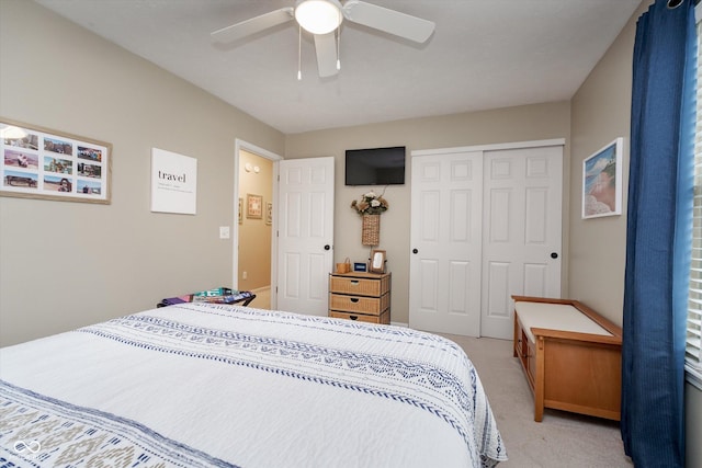 bedroom featuring light carpet, ceiling fan, and a closet