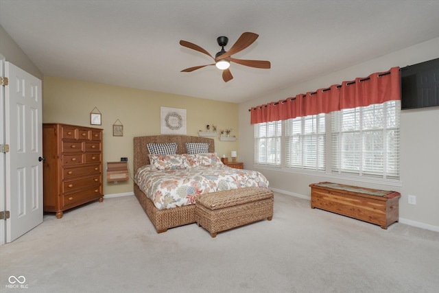 bedroom featuring light carpet, ceiling fan, and baseboards