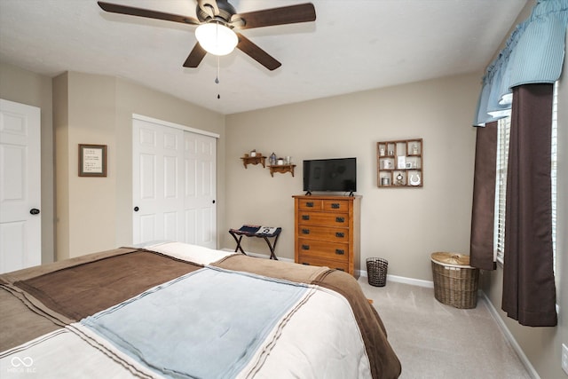 bedroom with ceiling fan, carpet floors, a closet, and baseboards