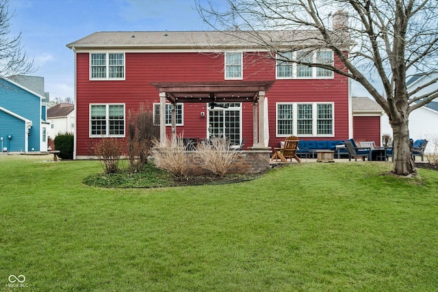 back of house featuring a yard, a patio, and a pergola