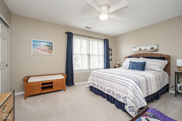 bedroom with baseboards, ceiling fan, visible vents, and light colored carpet