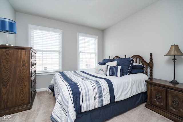 bedroom with vaulted ceiling and light carpet