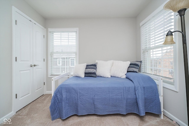 carpeted bedroom with baseboards and a closet