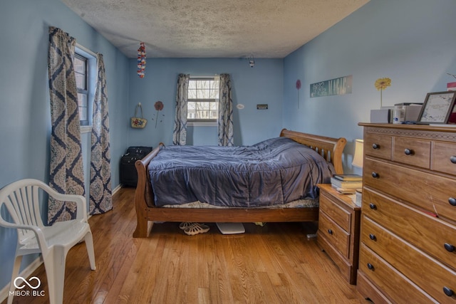 bedroom featuring a textured ceiling and light wood-style floors