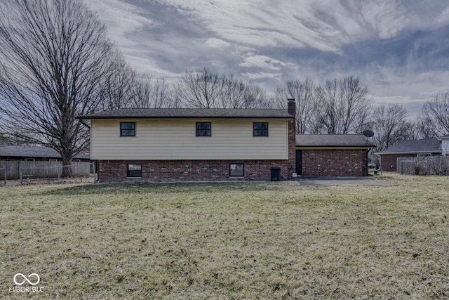 back of property with a yard, a chimney, and fence