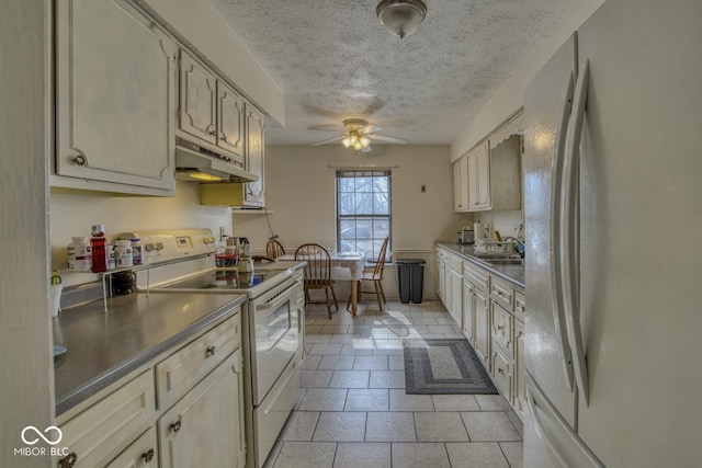 kitchen with ceiling fan, a textured ceiling, under cabinet range hood, white appliances, and dark countertops