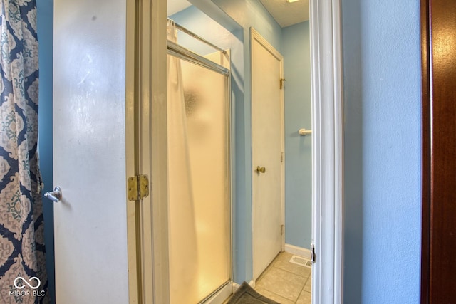 full bath with tile patterned flooring and a shower stall