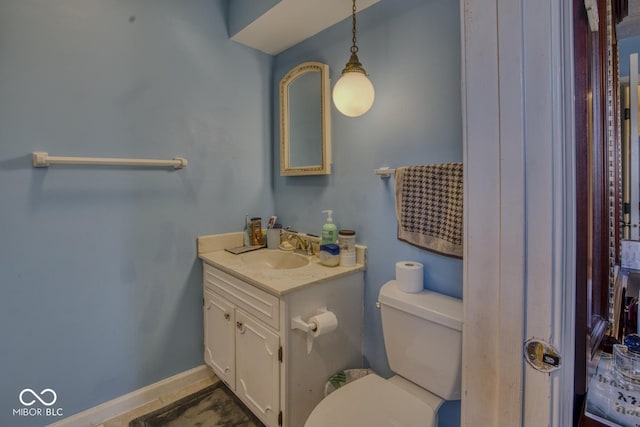 bathroom with vanity, toilet, and baseboards