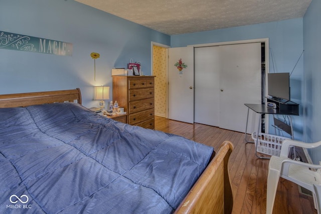 bedroom featuring a closet, a textured ceiling, and hardwood / wood-style floors