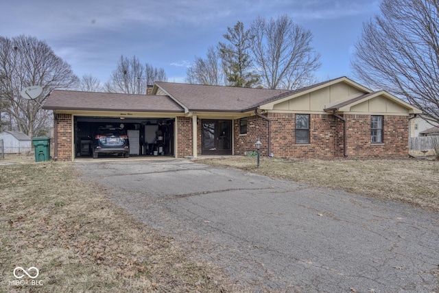 ranch-style home with driveway, an attached garage, a shingled roof, and brick siding