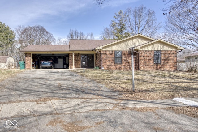 ranch-style house featuring driveway, brick siding, an attached garage, and a shingled roof