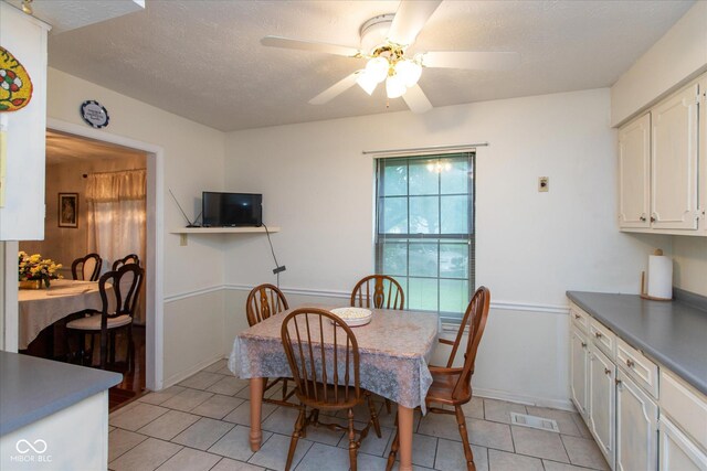 1612 Westbay Ct, Indianapolis, IN 46260 - dining room featuring light tile patterned floors, ceiling fan, a textured ceiling, and baseboards