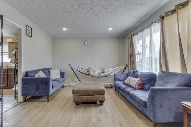 living room featuring plenty of natural light, light wood-style flooring, and a textured ceiling