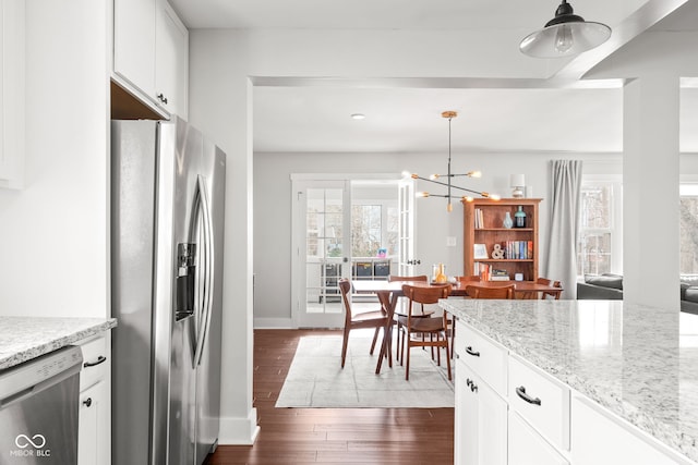 kitchen with dark wood finished floors, a healthy amount of sunlight, white cabinetry, and stainless steel appliances