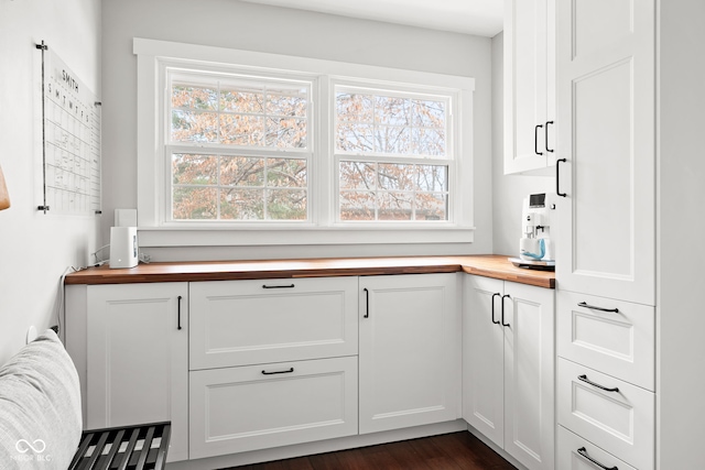 kitchen featuring white cabinetry, dark wood-style flooring, and butcher block countertops