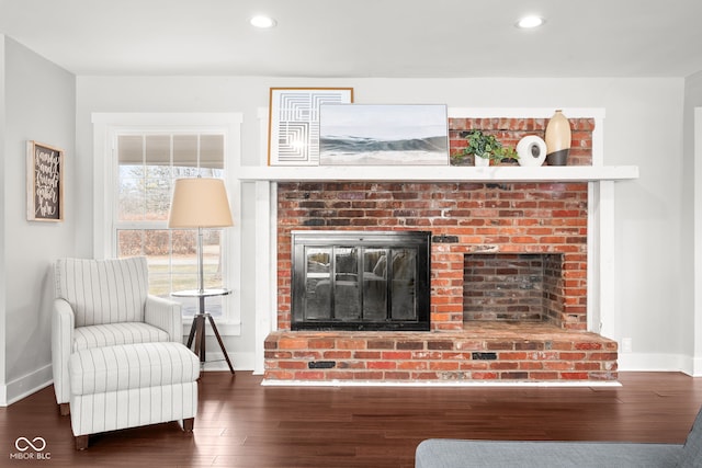 living area with a brick fireplace, recessed lighting, wood finished floors, and baseboards