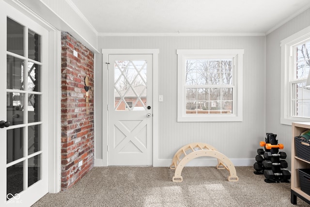 interior space featuring baseboards, ornamental molding, and carpet flooring