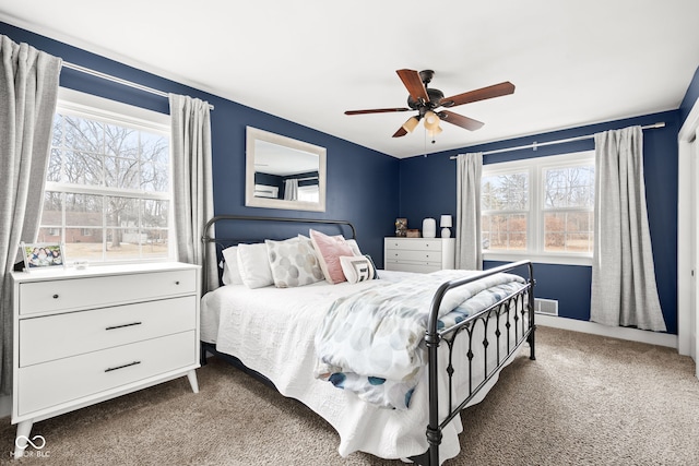 bedroom featuring multiple windows, a ceiling fan, visible vents, and carpet floors