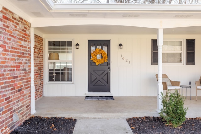 property entrance featuring brick siding and covered porch