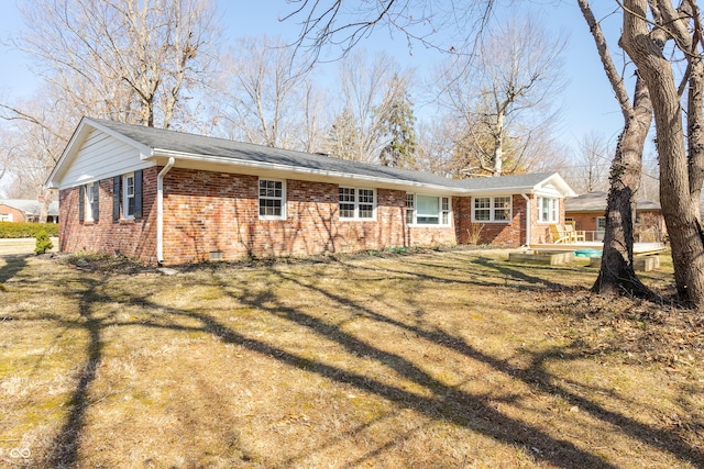 exterior space with crawl space, brick siding, and a front lawn