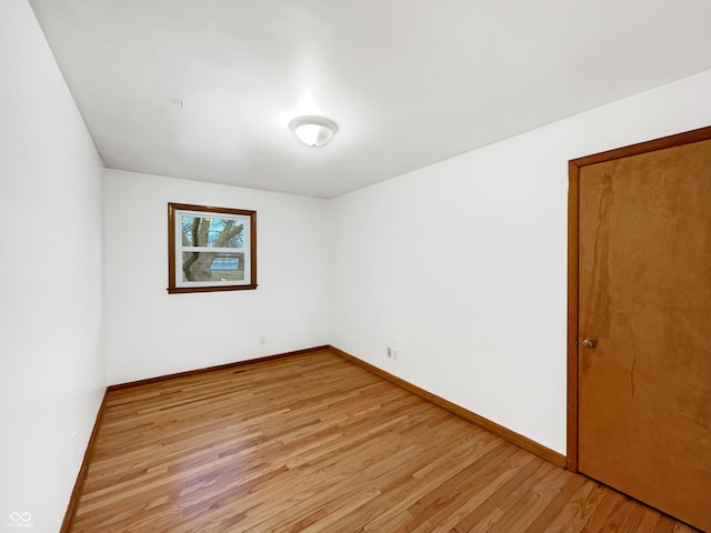 spare room with light wood-style flooring and baseboards