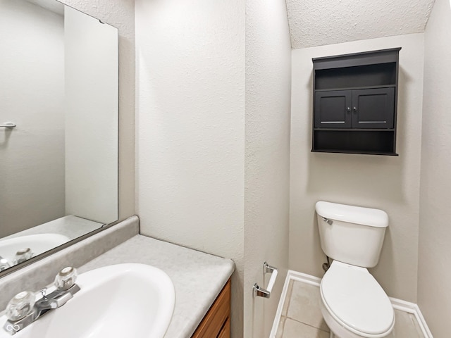 bathroom featuring baseboards, vanity, toilet, and tile patterned floors