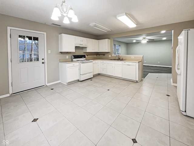 kitchen with white cabinets, a sink, white appliances, a peninsula, and under cabinet range hood