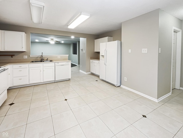 kitchen featuring white appliances, a sink, and white cabinets