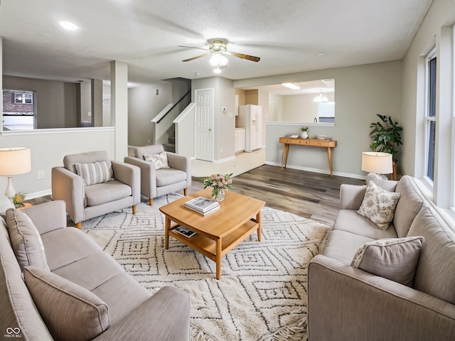 living room with stairway, baseboards, and wood finished floors