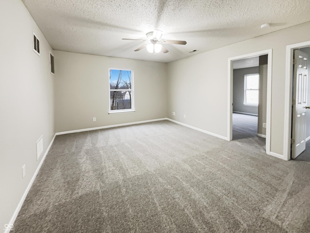 unfurnished room featuring baseboards, carpet floors, visible vents, and a ceiling fan