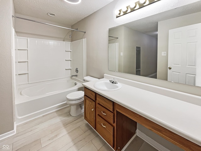 full bathroom with shower / bathtub combination, toilet, vanity, a textured ceiling, and wood finished floors