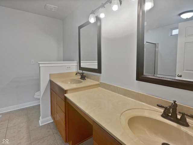 bathroom featuring toilet, baseboards, vanity, and tile patterned floors