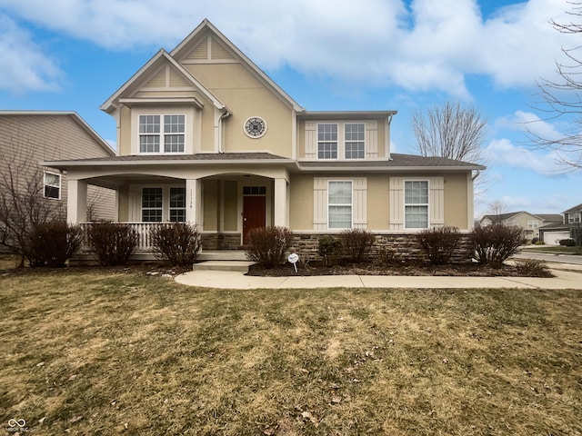 view of front of property featuring covered porch, stone siding, a front yard, and stucco siding